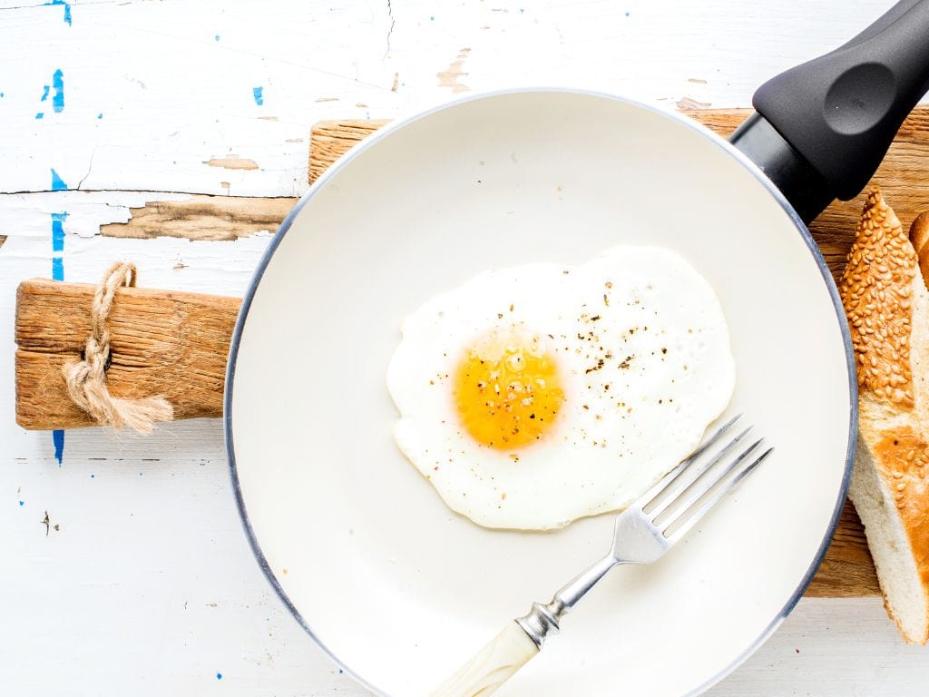 A delicious egg cooked in a ceramic frying pan.