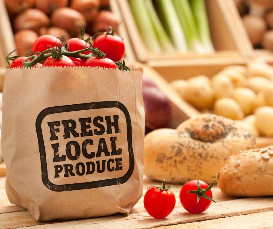 A bag of locally grown organic tomatoes sitting on a table. A bag of locally grown organic tomatoes