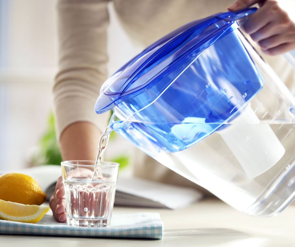 Pouring filtered water into a glass illustrates how to remove impurities and toxins. Pouring filtered water into a glass